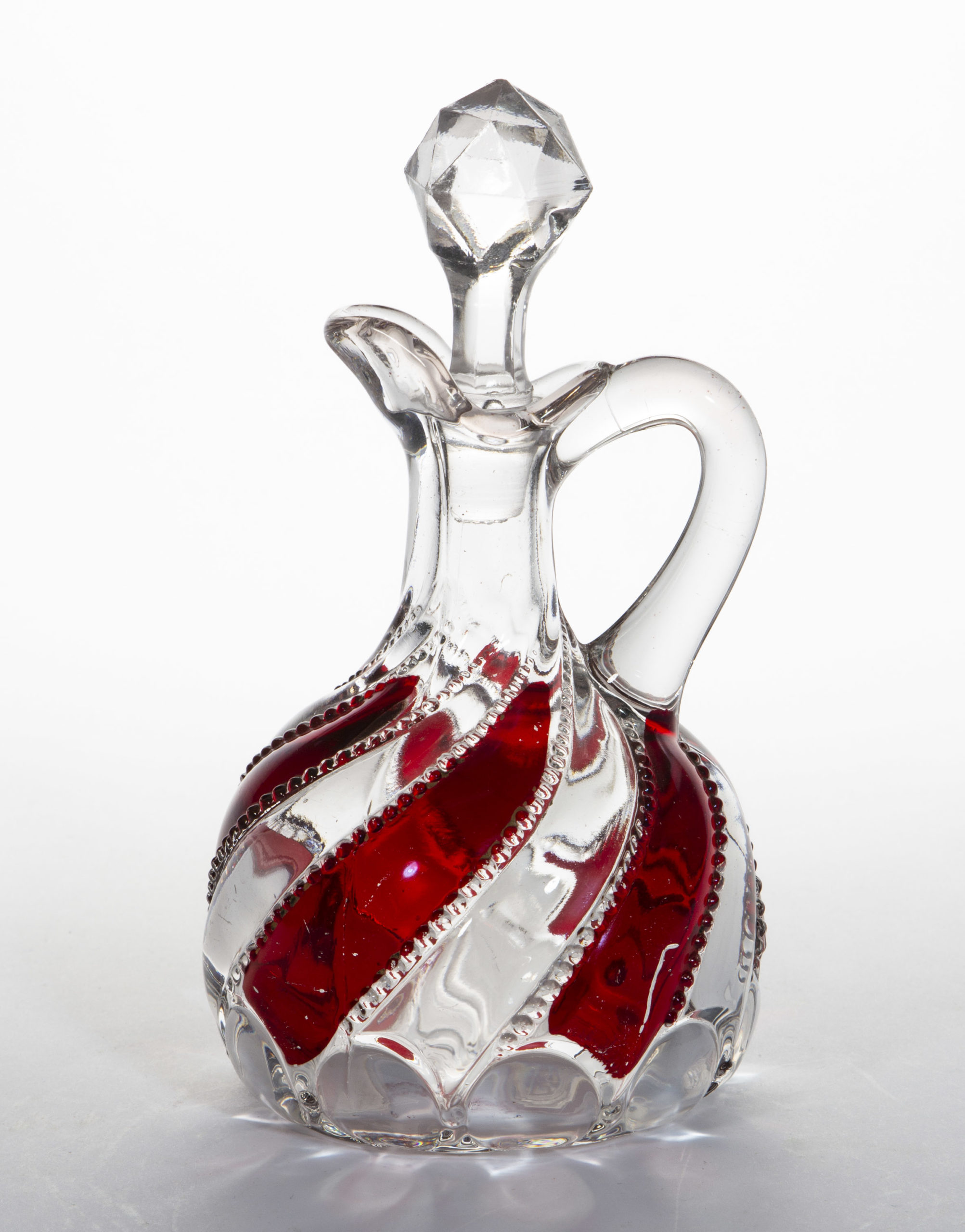 BEADED SWIRL WITH LENS – RUBY-STAINED CRUET,